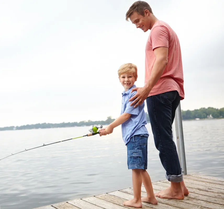 Father and son fishing from dock