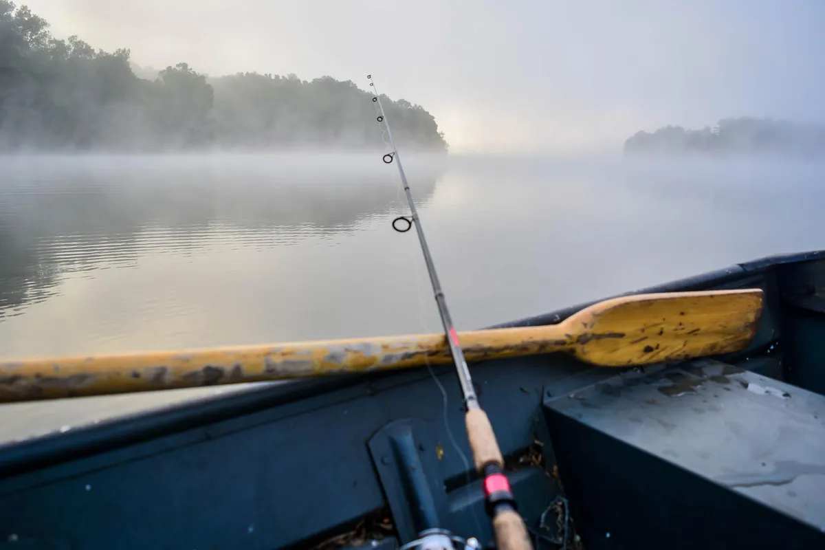 Fishing boat on foggy border water