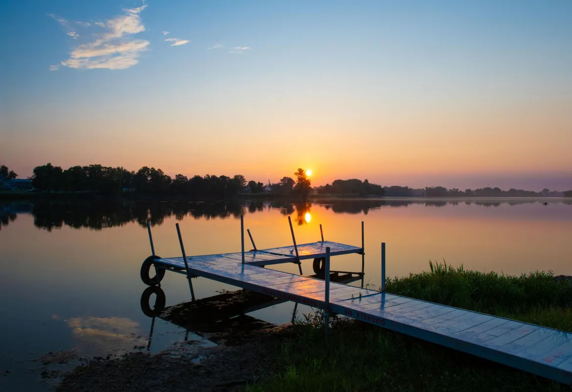 Fishing dock at sunrise on a calm lake